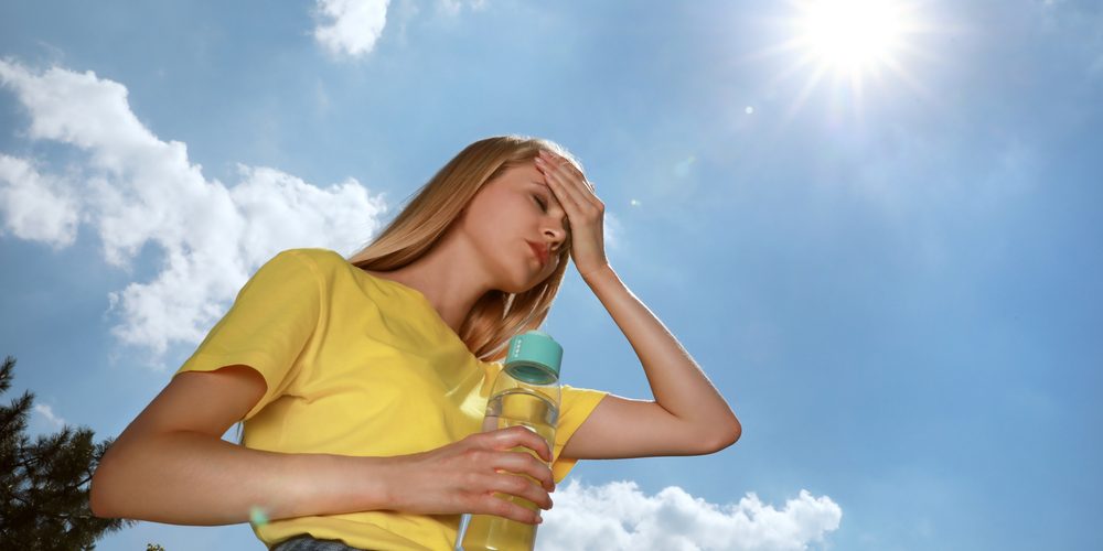 Woman,With,Bottle,Of,Water,Suffering,From,Heat,Stroke,Outdoors